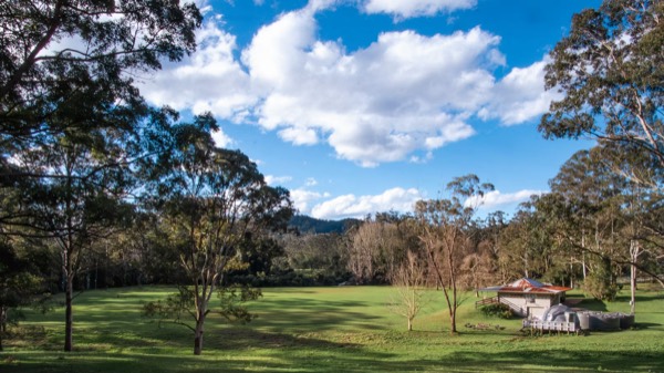 Panoramic view across the green Unwind Escapes property in the Dooralong Valley, Central Coast NSW