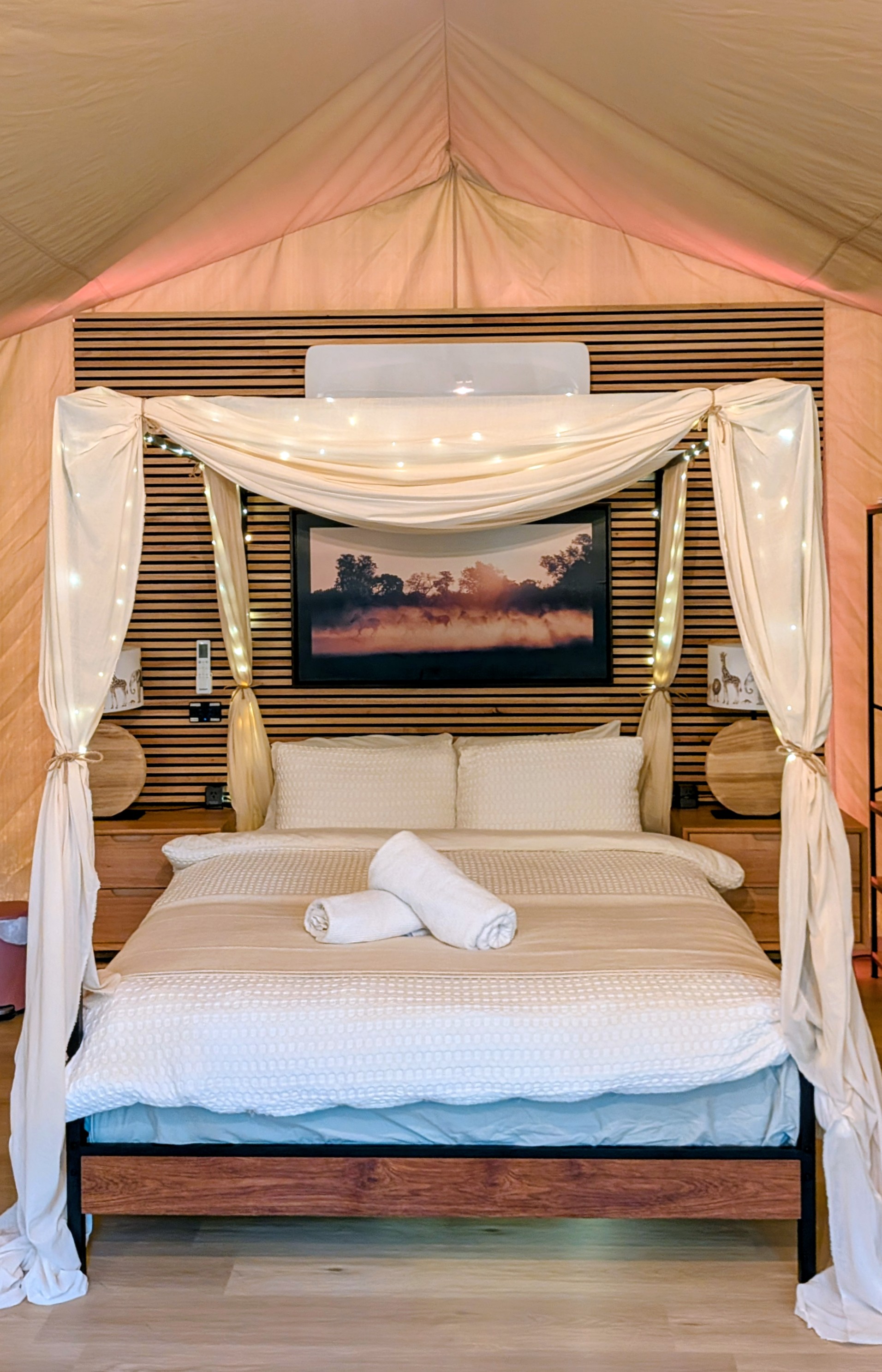 4-poster queen bed with sheer drapes and natural light through the glass doors