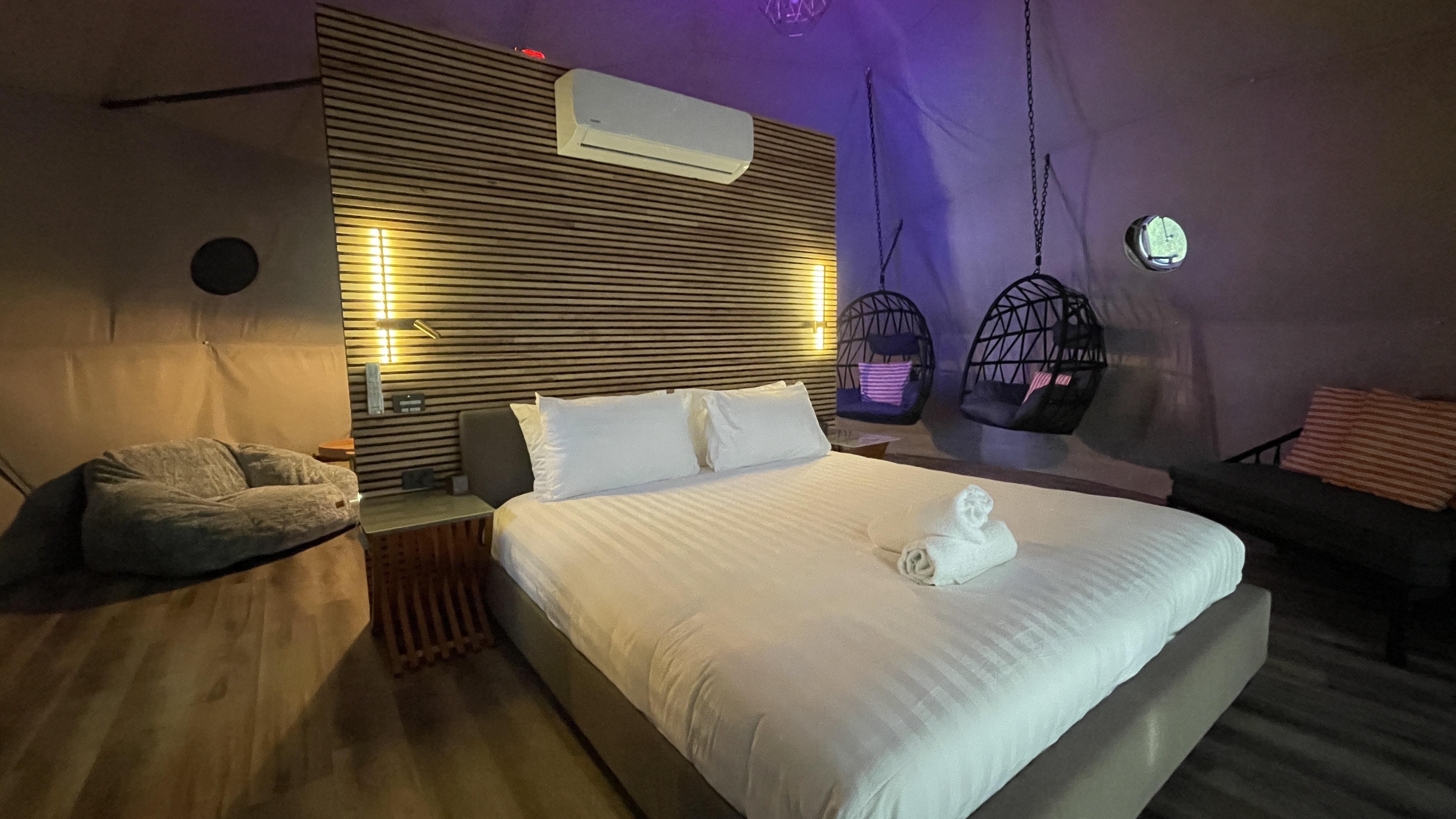 King bed with warm ambient lighting at dusk