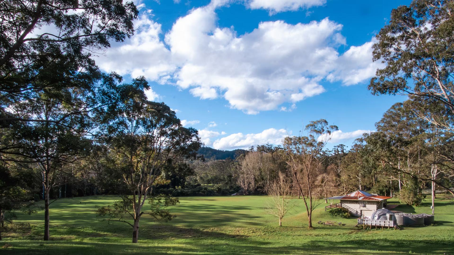 Panoramic view across the Unwind Escapes glamping property in the Dooralong Valley, Central Coast NSW